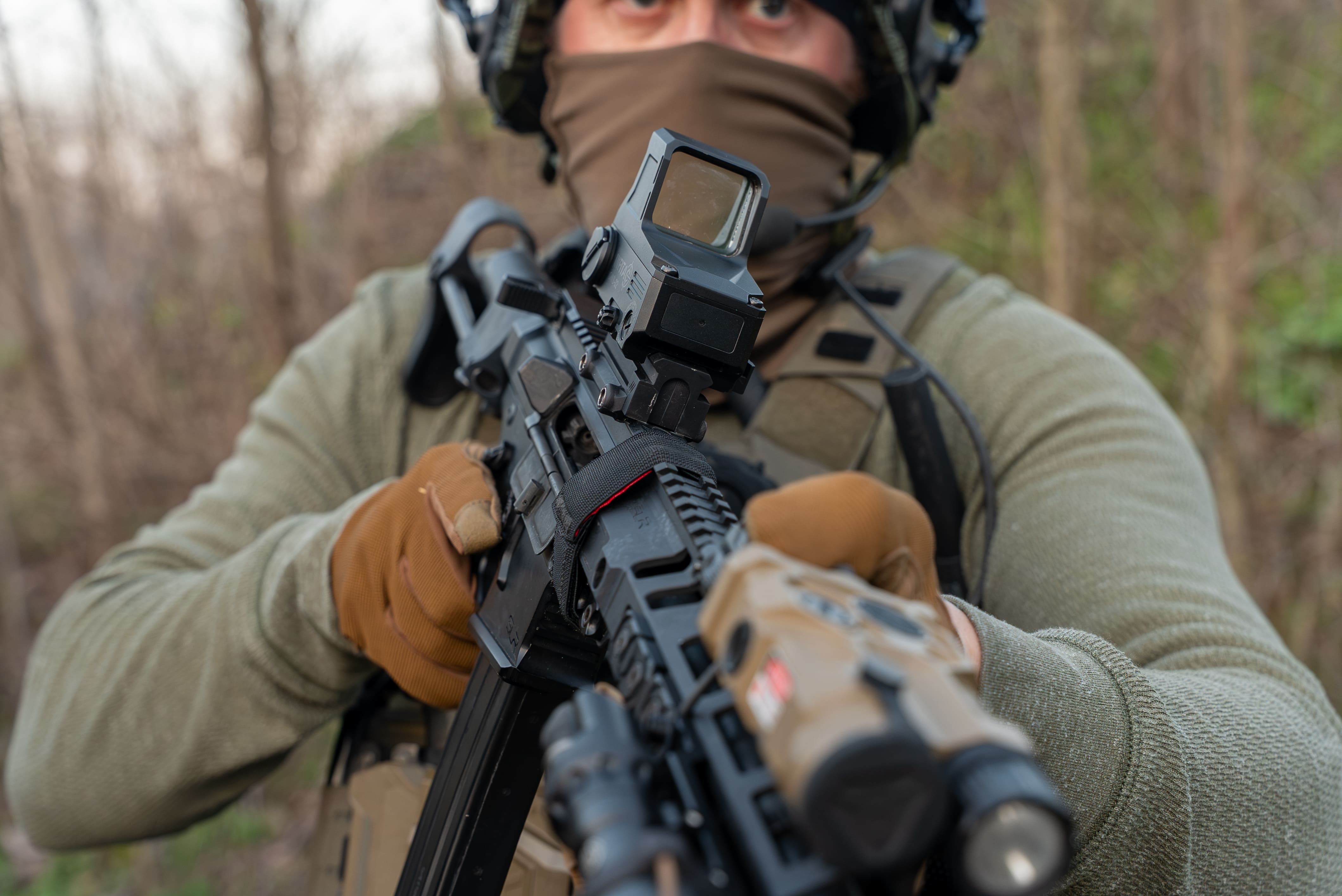 Front view of a shooter in a balaclava focusing through the Infitac OWS-32 OPTICAL WAVEGUIDE SIGHT
