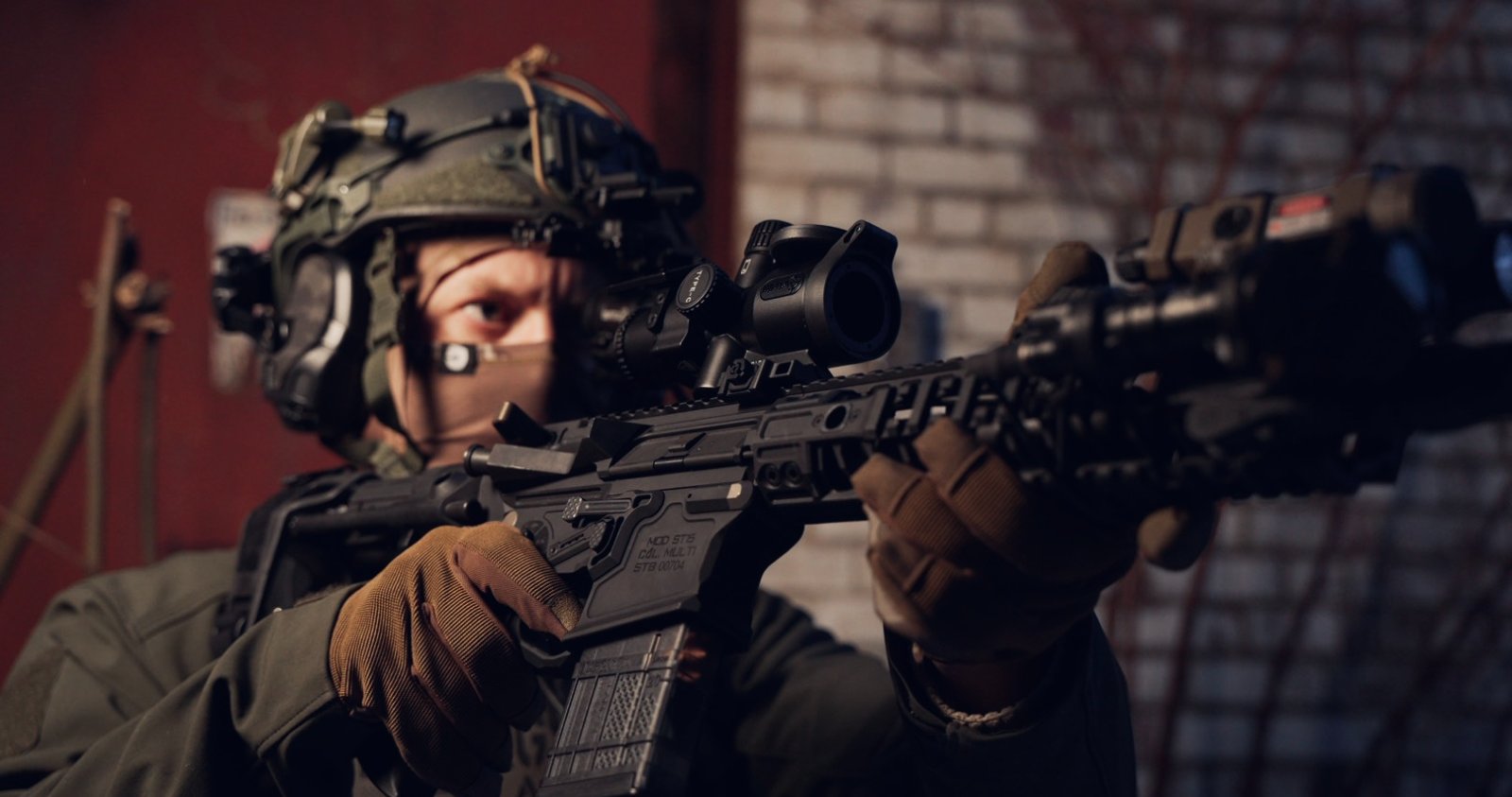 Tactical operator aiming a rifle with Thermal Rifle Sights IOTS IOL25 for precision in low-light urban settings