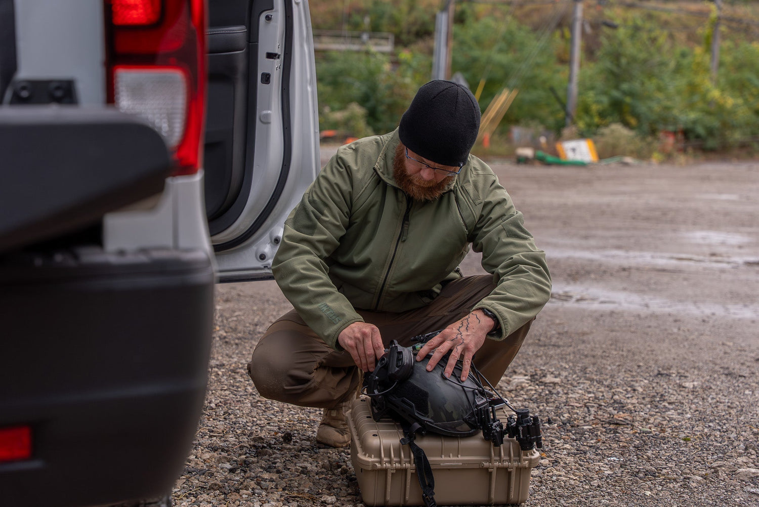 Man in tactical gear adjusts night vision on a helmet
