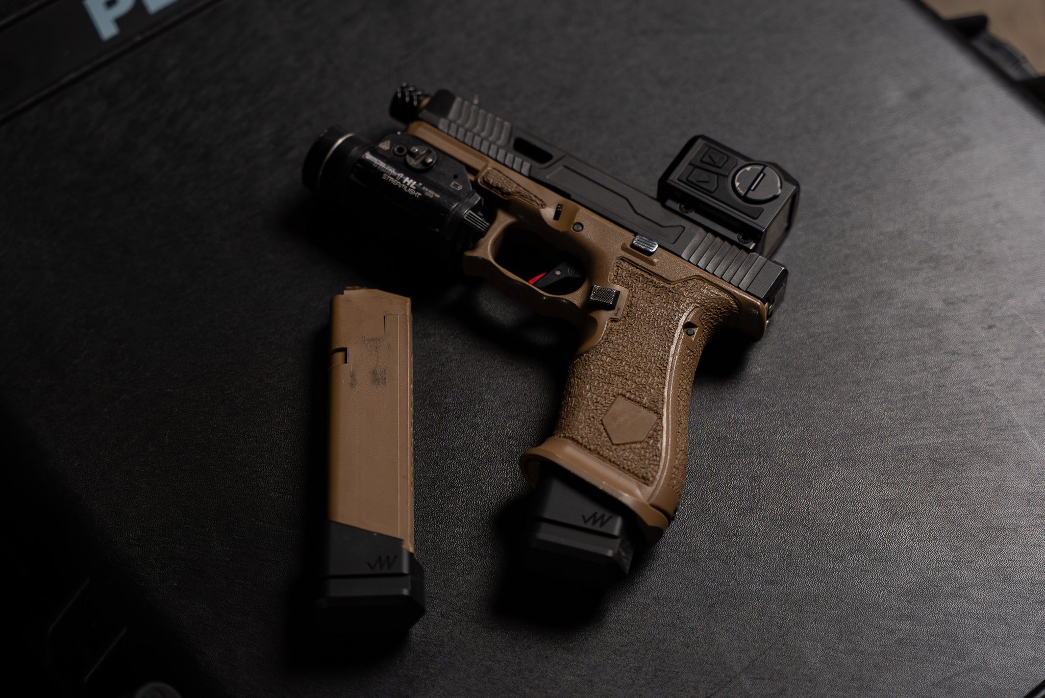 Custom tan and black pistol with red dot sight and magazine