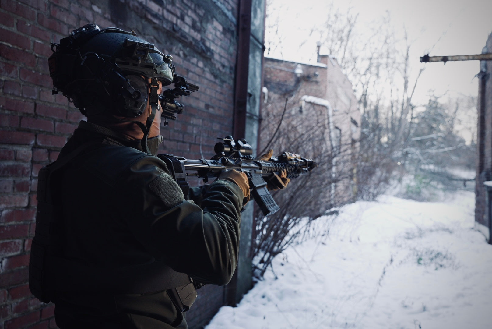Soldier with rifle and Infitac night vision in snowy urban area